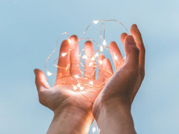 person holding string lights